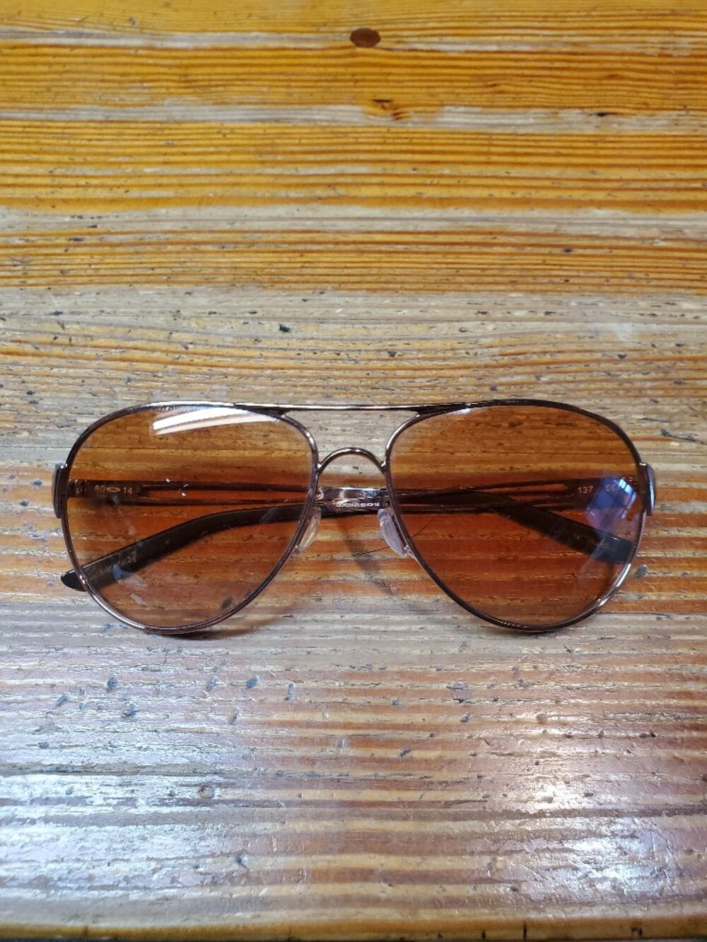 Oakley Caveat aviator sunglasses featuring a rose gold metal frame and warm brow
